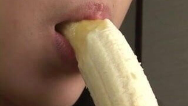 Beautiful Japanese girl sexily eating a banana